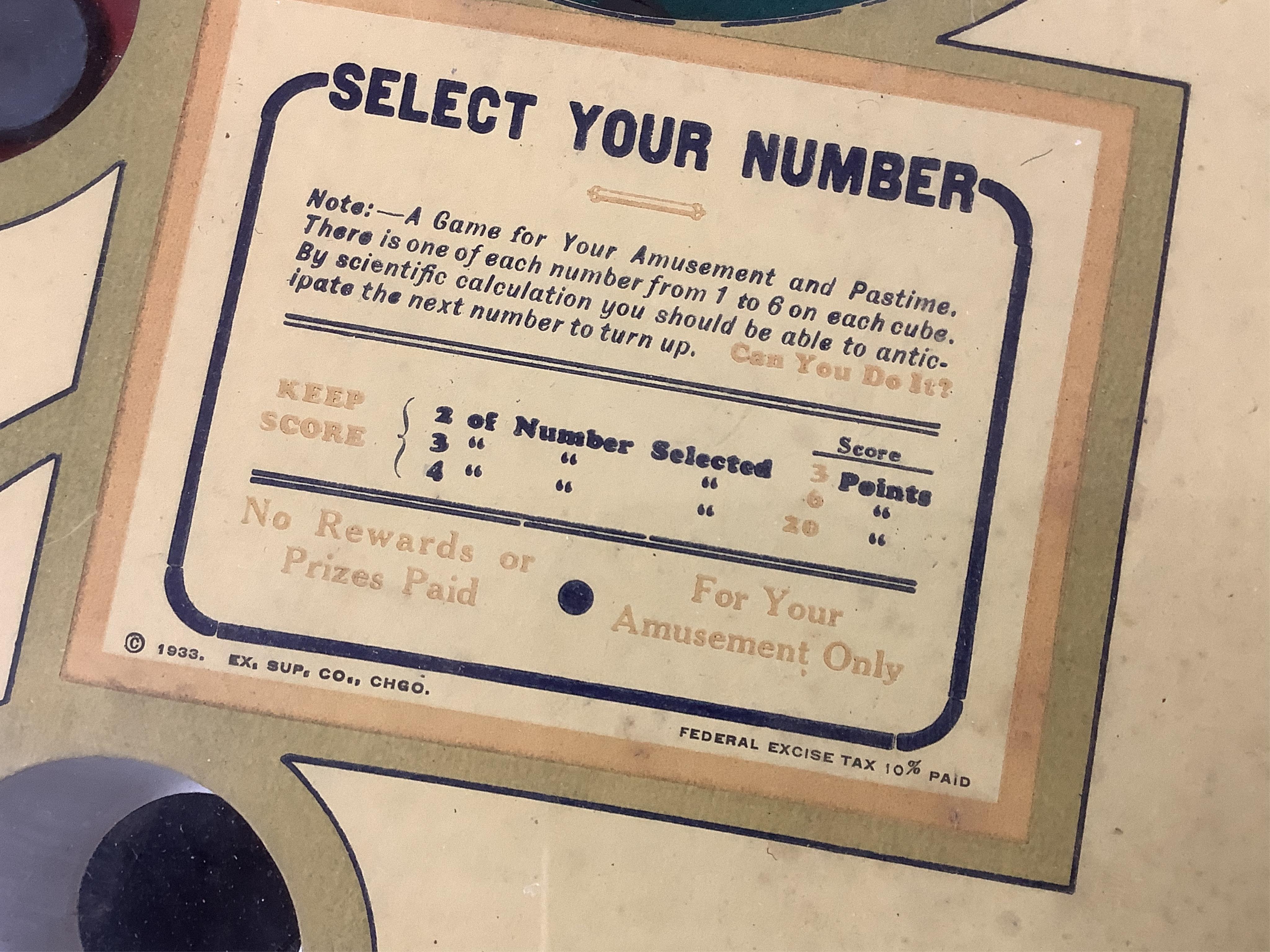 A ‘Select-Em’ table top pinball style dice game in a teak frame dated 1933, with Board of Equalization sales tax permit label for the State of California, 26cm wide, 35.5cm deep, 12.5cm high